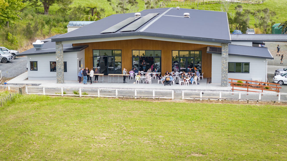 an image of the exterior of the Tangiteroria Community Complex showing adults enjoying the outside space